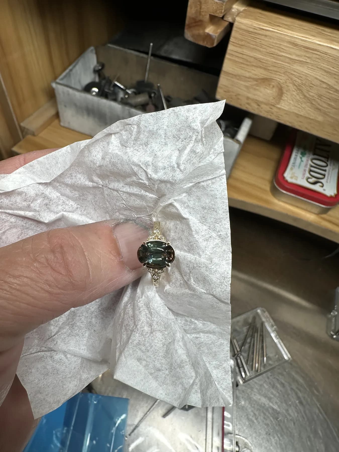 Finished custom yellow-toned ring with an oval dark-green gemstone