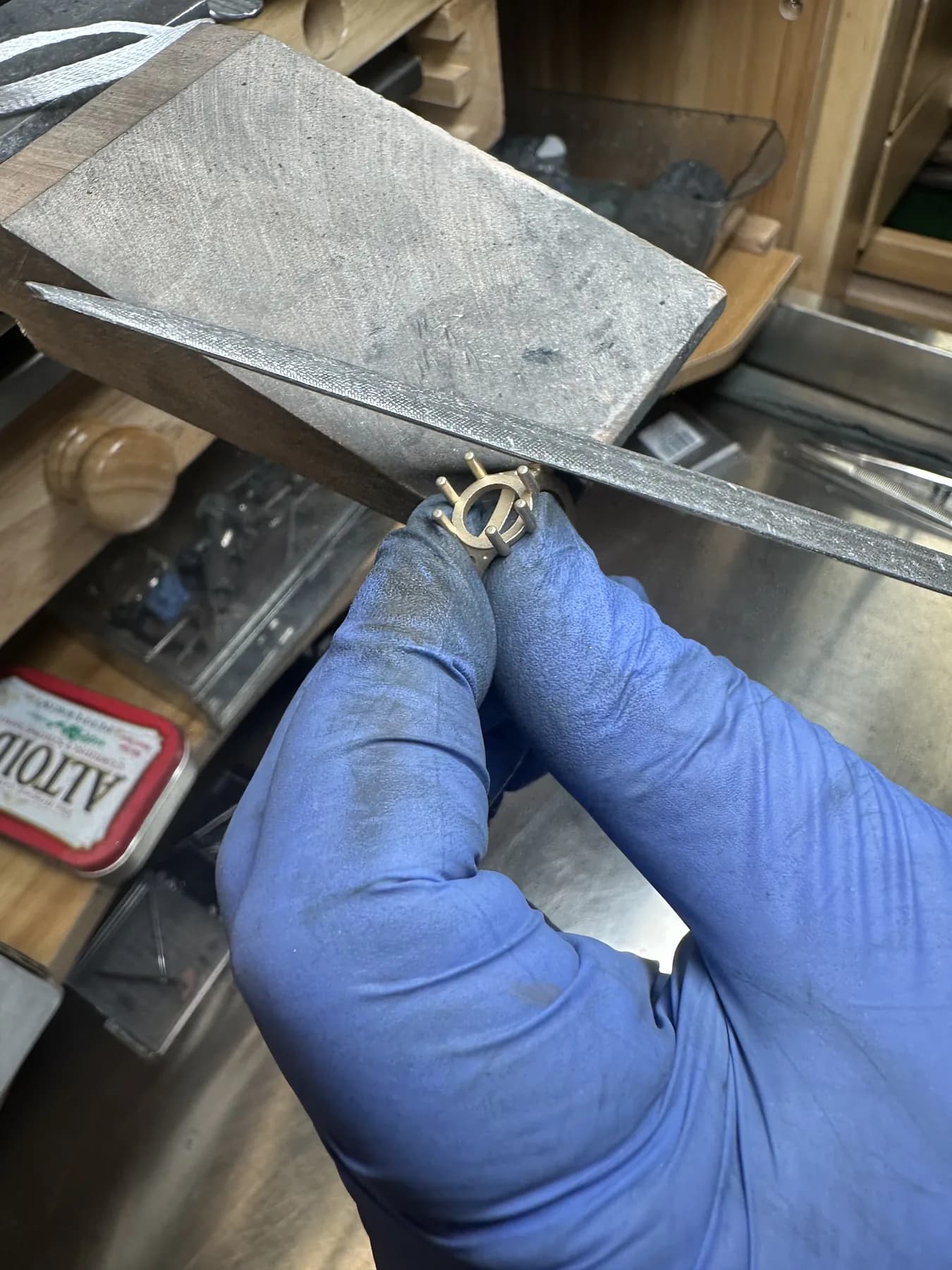 Jeweler hand-filing a custom yellow-toned ring setting