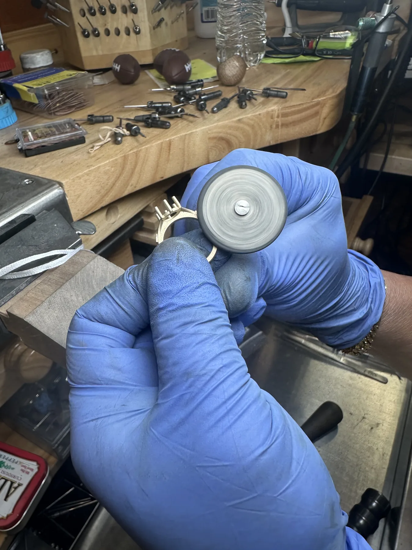 Jeweler polishing a custom ring setting by hand at the bench